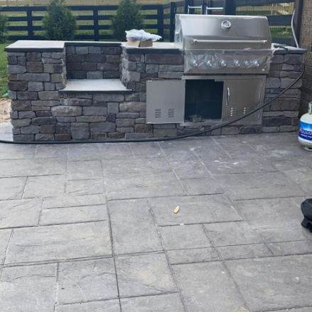 Stone outdoor kitchen with built-in grill